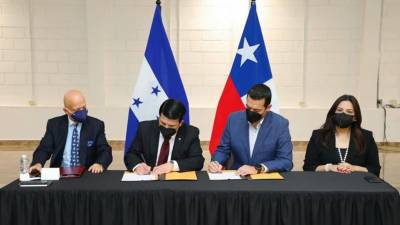Funcionarios de los gobiernos de Chile y Honduras firmando la donación de fondos.