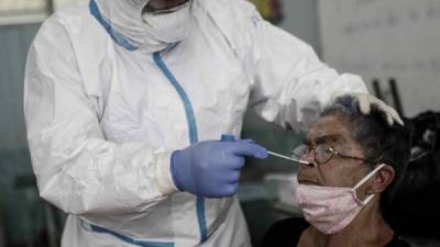 Un profesional sanitario realiza una prueba de COVID-19 en la localidad de Pavas, al oeste de San José.