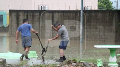 Hondureños que perdieron muchas de sus pertenencias por las inundaciones, han regresado a su casa para realizar labores de limpieza.