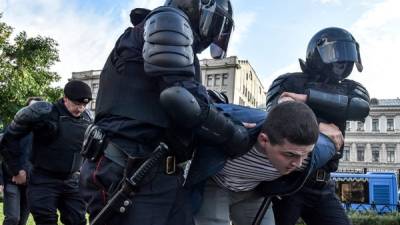 Los oficiales de seguridad rusos detienen a un hombre después de una manifestación que convocó a elecciones justas en el centro de Moscú.