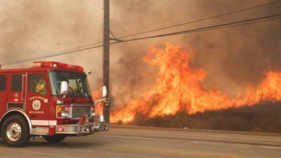 Un camión de bombero pasa frente a un incendio en Anaheim Hills, California. EFE
