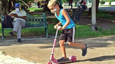 Un niño protegido con tapabocas fue registrado este miércoles al jugar en un parque de La Habana (Cuba).