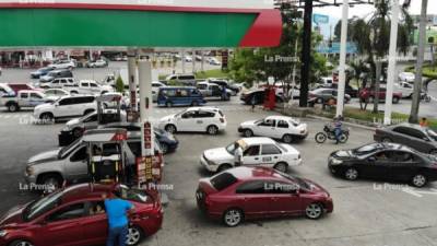 Varios conductores hacen fila para llenar de combustibles los tanques de sus vehículos.