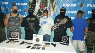 Los tres capturados mientras son presentados y costodiados por agentes antimaras.