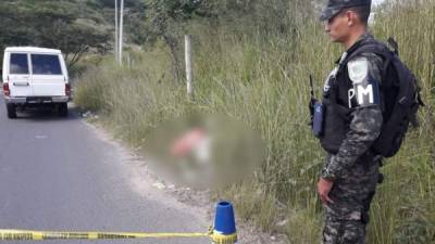 Escena del crimen custodiada por un agente del orden en Honduras.