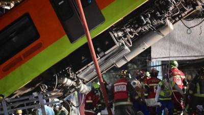 Los rescatistas retiran un cuerpo de un vagón de tren después de que una línea elevada de metro colapsara en la Ciudad de México. Foto AFP