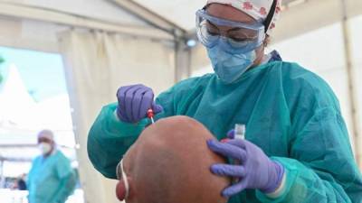 Una sanitaria realiza un test PCR a un vecino de Torrejón de Ardoz, Madrid.