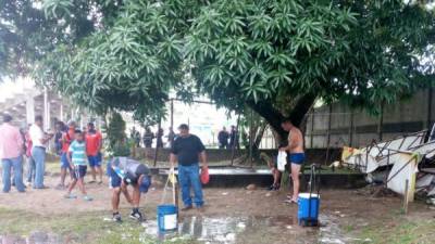 Los jugadores de la UPN mientras se bañaban con baldes de agua al aire libre.