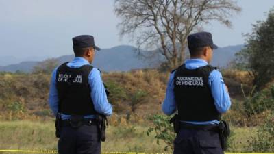 Foto de archivo de dos policías resguardando una escena de crimen.