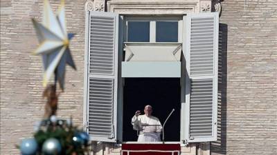 El Papa Francisco bañado por la luz del sol durante la tradicional oración del Ángelus en el segundo día de Navidad desde un balcón de la Plaza de San Pedro. EFE