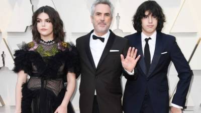 Alfonso Cuarón (c) con sus hijos Tess Bu (i) y Olmo Teodoro (d) a su paso por la alfombra roja de los Óscar 2019. AFP