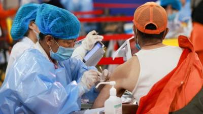 Un trabajador de saneamiento recibe la vacuna contra el coronavirus en China. Foto AFP
