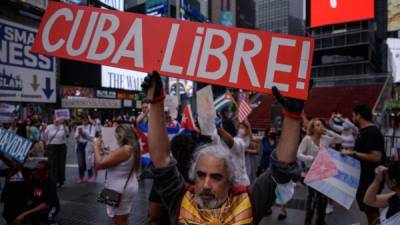 Los manifestantes sostienen pancartas durante una manifestación de solidaridad con las protestas antigubernamentales en Cuba. Foto AFP