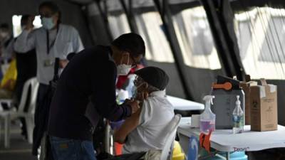 Un anciano es inoculado con la vacuna Oxford / AstraZeneca en el centro de vacunación de Roosevelt Field en la ciudad de Guatemala. Foto AFP
