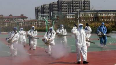 Voluntarios rociando desinfectante en los compuestos de una escuela mientras se prepara para reabrir después de que se retrasó la apertura debido al brote de coronavirus COVID-19, en Weifang, China. Foto AFP