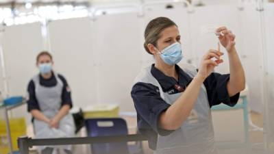 Los médicos preparan jeringas antes de administrar inyecciones de la vacuna Oxford / AstraZeneca en Inglaterra. Foto AFP