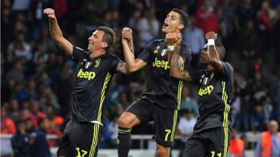 Cristiano Ronaldo celebra con Mario Mandzukic y Douglas Costa al final del partido en Parma. Foto AFP