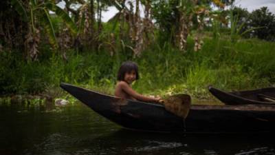 Una niña de la etnia indígena Warao viaja en una piragua en el río Morichal de Venezuela.