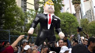 Los manifestantes queman una figura de Trump frente al recinto de la Embajada de Estados Unidos en la ciudad de México, el 20 de enero de 2017.