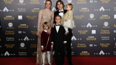 El centrocampista croata del Real Madrid, Luka Modric, su mujer Vanja Bosnic y sus hijos posan para los fotógrafos a su llegada a la gala del Balón de Oro en el Grand Palais de París.