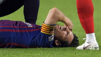 Messi con gestos de dolor tras el golpe que sufrió en el brazo derecho en el partido contra Sevilla. Foto AFP