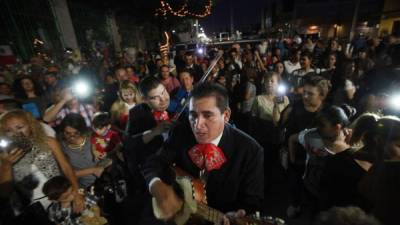 Centenares de personas rinden homenaje cantando sus canciones y llevando ofrendas florales a la casa de Juan Gabriel en Ciudad Juárez.