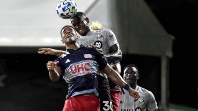 Romell Quioto disputa el balón con Brandon Bye del New England Revolution. Foto AFP