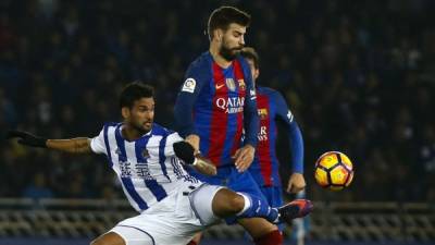 El defensa del Barcelona, Gerard Piqué (d), disputa un balón con el delantero brasileño de la Real Sociedad, Willian José. Foto EFE