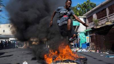 Un joven salta una barricada en llamas cerca del mercado de Petionville, durante una jornada de protestas este jueves, en Puerto Príncipe (Haití). Puerto Príncipe amaneció este jueves con numerosas barricadas, bloqueos en las carreteras e incendios intencionados en el inicio de una nueva jornada de movilización convocada por grupos opositores contra el presidente, Jovenel Moise. La jornada de movilización de este jueves ha sido planteada por la oposición como un día de 'levantamiento general' de las clases populares y campesinas contra el jefe de Estado. EFE/ Orlando Barría