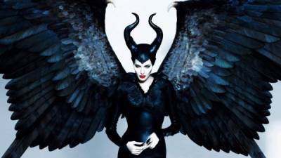 Angelina aparece caracterizada como una bruja con alas, dos cuernos negros y retorcidos en la cabeza.