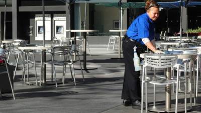 Una mujer limpia las mesas de un restaurante ubicado en la parte baja de Los Ángeles