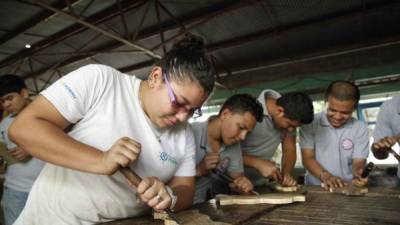 Dionela Patricia Prudencio y sus compañeros en el taller de tallado.