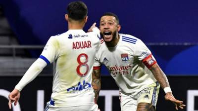 Houssem Aouar celebrando su gol con Memphis Depay. Foto AFP