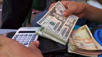 Cambista de dólares en el parque central de San Pedro Sula hace unos cálculos. Foto: Amílcar Izaguirre