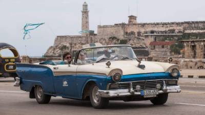 Esta foto de archivo del 08 de enero 2014 muestra a los turistas en su viaje en un taxi, en La Habana. AFP