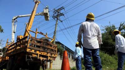 Cuadrillas de la Enee en labores de mantenimiento en postes de energía.