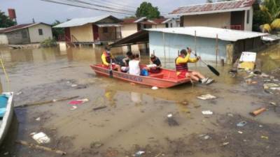 Bomberos rescatan en una lancha a una familia en La Lima, Cortés, uno de los municipios más afectados por Eta.