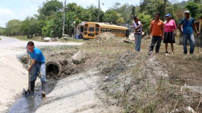 Un joven limpia una de las cunetas en la aldea El Carmen. Fotos: Franklyn Muñoz