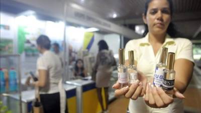 Una mujer sostiene los perfumes 'Hugo', 'Ernesto', 'Alba' y 'Amalia' el 25 de septiembre de 2014, durante el Congreso Labiofam 2014, en La Habana (Cuba). Foto de EFE.