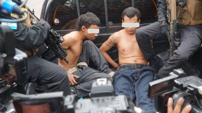 Imagen de archivo muestra a dos presuntos pandilleros capturados durante una redada en San Pedro Sula este año.