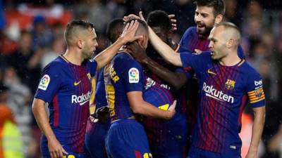 Paco Alcácer es felicitado por los jugadores del Barcelona tras marcar un gol al Sevilla. Foto AFP