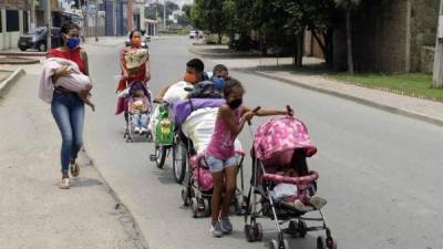 Una familia de venezolanos camina por la ciudad durante el primer día de cuarentena decretada por el Gobierno para contener la expansión del COVID-19 este miércoles en Cúcuta (Colombia). EFE