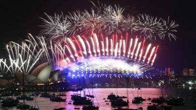 Espectacular escena de juegos artificiales que iluminan la ópera de Sídney y el puente Harbour para recibir el nuevo año. afp