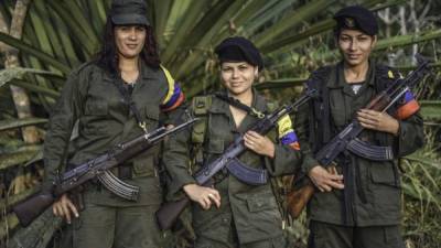 (L to R) Luisa, Manuela and Rosmira, members of the Revolutionary Armed Forces of Colombia (FARC), pose for a picture at a camp in the Colombian mountains on February 18, 2016. Many of these women are willing to be reunited with the children they gave birth and then left under protection of relatives or farmers, whenever the peace agreement will put an end to the country's internal conflict. AFP PHOTO / LUIS ACOSTA