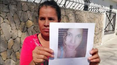 Un familiar de la joven asesinada muestra una de las fotografías en vida de la víctima.