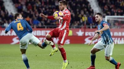 El jugador del Girona, Portu, es marcado por los colchoneros Santiago Arias y Koke. Foto AFP