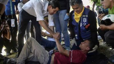 Guaidó saluda a un venezolano afectado por la escasez de alimentos durante un evento de médicos voluntarios en Caracas./AFP.