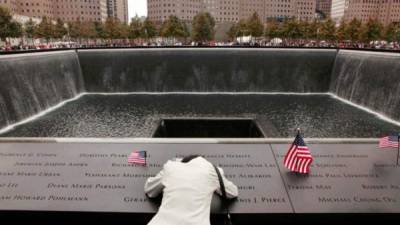 Una mujer llora sobre el memorial de las víctimas de los atentados del 11 de septiembre.
