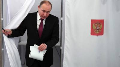El presidente Vladimir Putin sale de una cabina de votación en una mesa de votación durante las elecciones presidenciales de Rusia en Moscú el 18 de marzo de 2018.