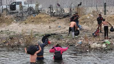 Migrantes se preparan para cruzar el Río Bravo, en la frontera que divide a México de los Estados Unidos, en Ciudad Juárez.